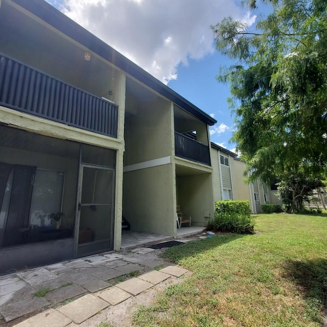 912 Lake Destiny Rd Unit F, Altamonte Springs, FL 32714 - rear view of house featuring stucco siding, a yard, a balcony, and a patio area