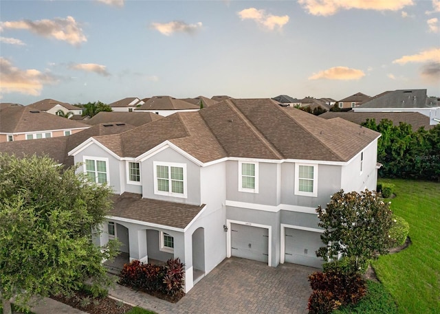 14572 Black Quill Dr, Winter Garden, FL 34787 - view of front of home with stucco siding, a garage, roof with shingles, driveway, and a front yard