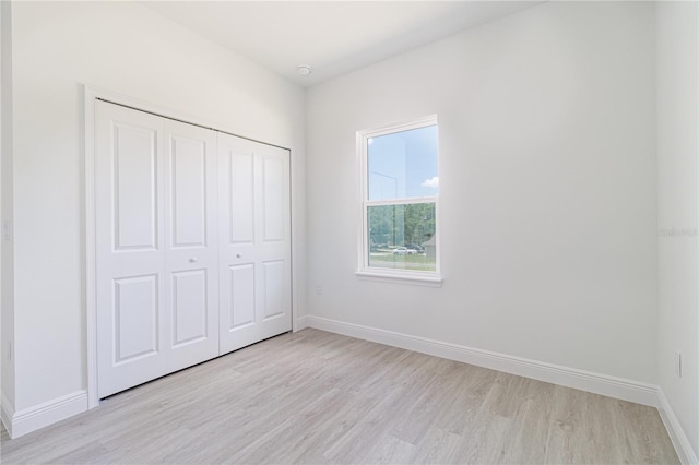 7229 N Gibralter Dr, Citrus Springs, FL 34434 - unfurnished bedroom with light wood finished floors, a closet, and baseboards
