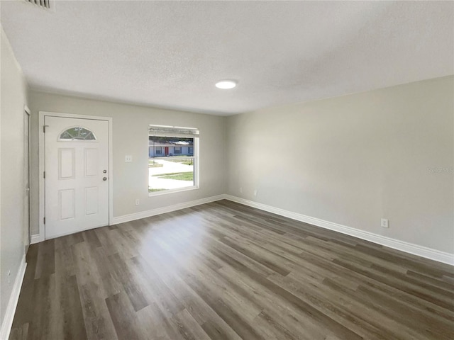 entrance foyer featuring dark wood-style floors, baseboards, and a textured ceiling