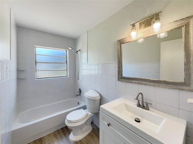 full bathroom with tile walls, toilet, shower / tub combination, wood finished floors, and vanity