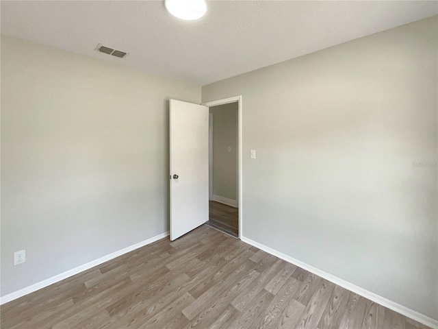 spare room with wood finished floors and baseboards