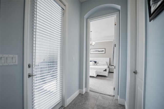 hallway with baseboards and marble finish floors