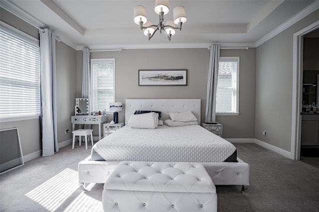 carpeted bedroom featuring a chandelier, a tray ceiling, multiple windows, and baseboards