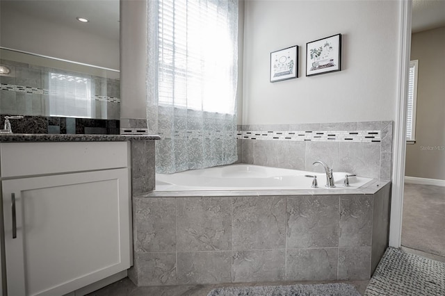 bathroom with vanity and a garden tub