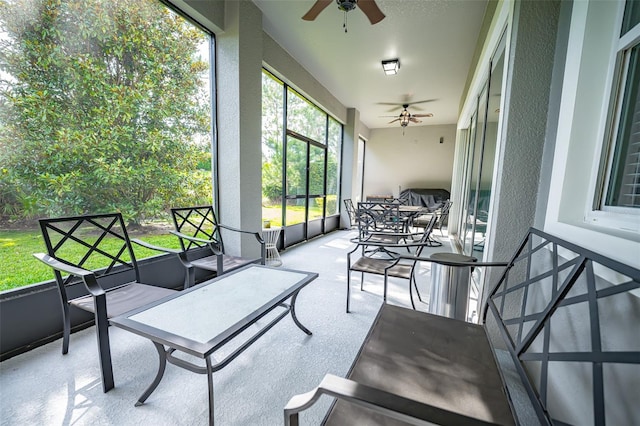 sunroom with a ceiling fan and an outdoor living space