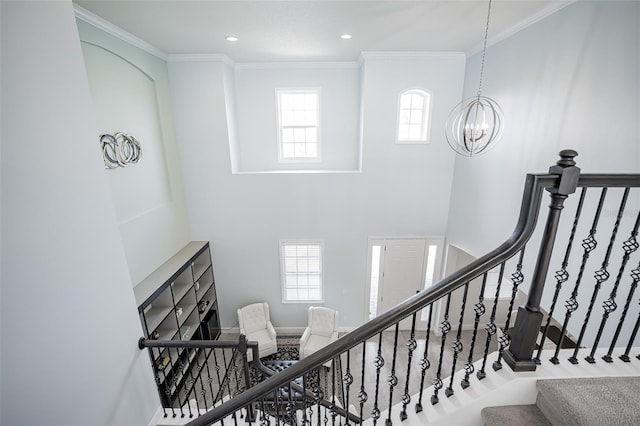 stairs featuring crown molding, a high ceiling, and a chandelier
