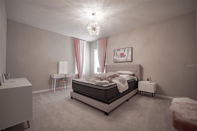 bedroom featuring light carpet, baseboards, and a chandelier
