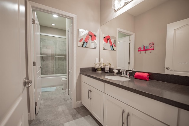 bathroom featuring vanity, toilet, bath / shower combo with glass door, and baseboards