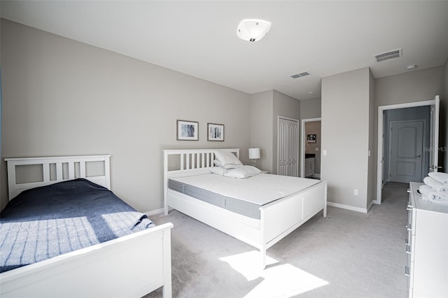 bedroom with light carpet, baseboards, and a closet