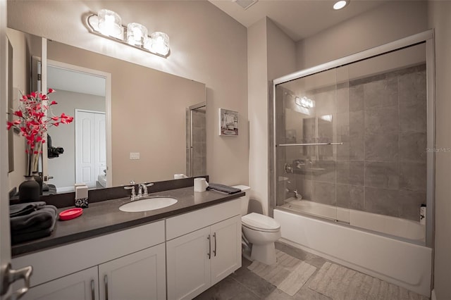 bathroom featuring toilet, vanity, shower / bath combination with glass door, and tile patterned flooring