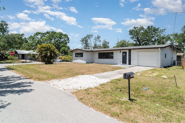 ranch-style house featuring a garage, a front yard, and driveway