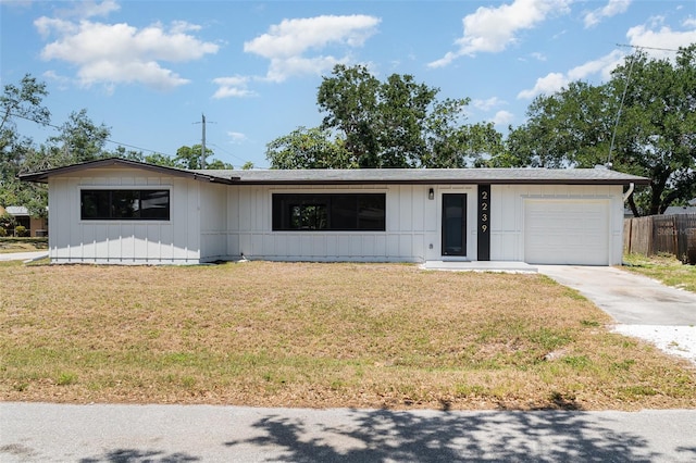 ranch-style home with a garage, driveway, and board and batten siding