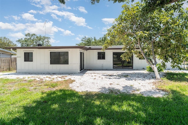 rear view of property featuring board and batten siding and a patio area