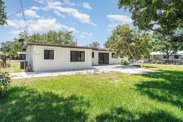 back of house with board and batten siding, a patio area, and central air condition unit
