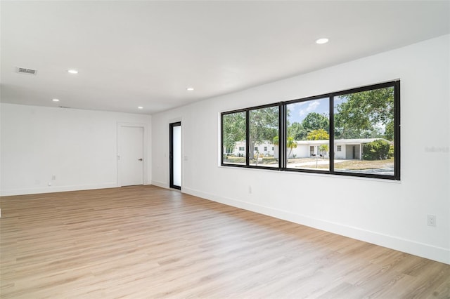 spare room featuring recessed lighting, light wood finished floors, and baseboards