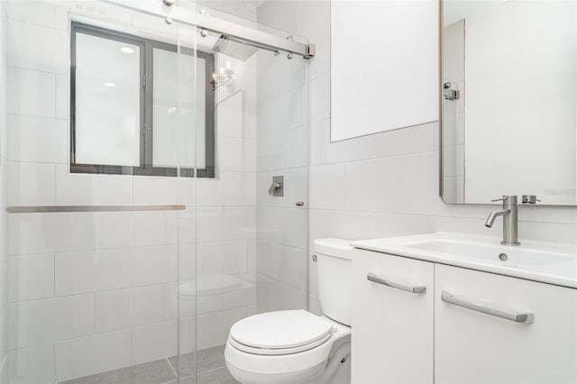 full bathroom with tile walls, a stall shower, toilet, and vanity