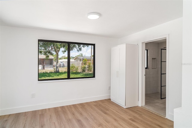 unfurnished bedroom featuring light wood-style flooring and baseboards