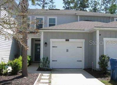 204 Pasadena Dr, Saint Augustine, FL 32095 - view of front of home featuring board and batten siding, concrete driveway, a garage, and roof with shingles