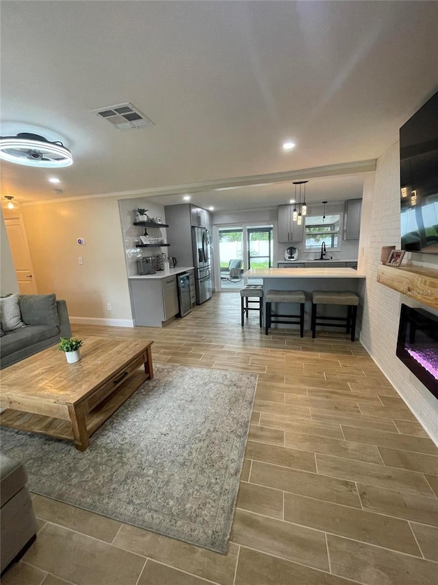 9153 86th Ave, Seminole, FL 33777 - living room with light wood-type flooring, a fireplace, baseboards, and recessed lighting
