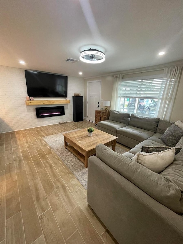 9153 86th Ave, Seminole, FL 33777 - living area with wood finished floors, brick wall, and a glass covered fireplace