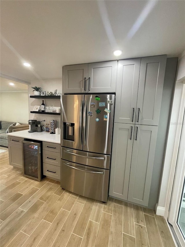 9153 86th Ave, Seminole, FL 33777 - kitchen with stainless steel fridge with ice dispenser, beverage cooler, light wood-type flooring, gray cabinetry, and open shelves