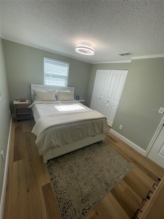 9153 86th Ave, Seminole, FL 33777 - bedroom with wood finished floors, a textured ceiling, baseboards, and a closet