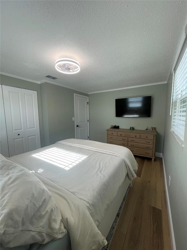 9153 86th Ave, Seminole, FL 33777 - bedroom with a textured ceiling, wood finished floors, baseboards, crown molding, and a closet