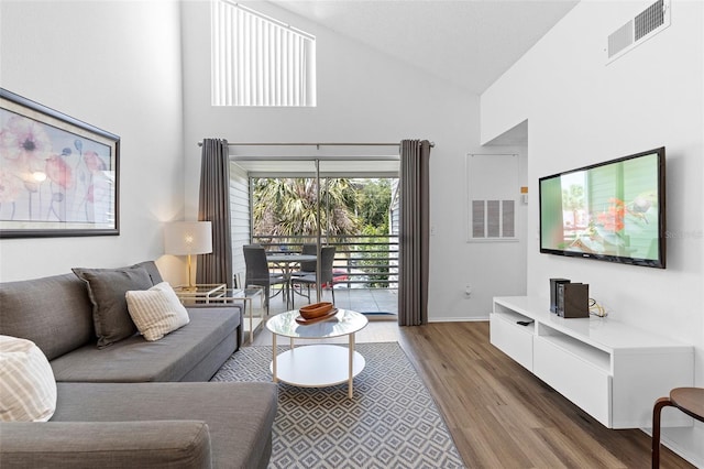3900 Southpointe Dr Unit 127, Orlando, FL 32822 - living room with high vaulted ceiling, light wood-style floors, and baseboards
