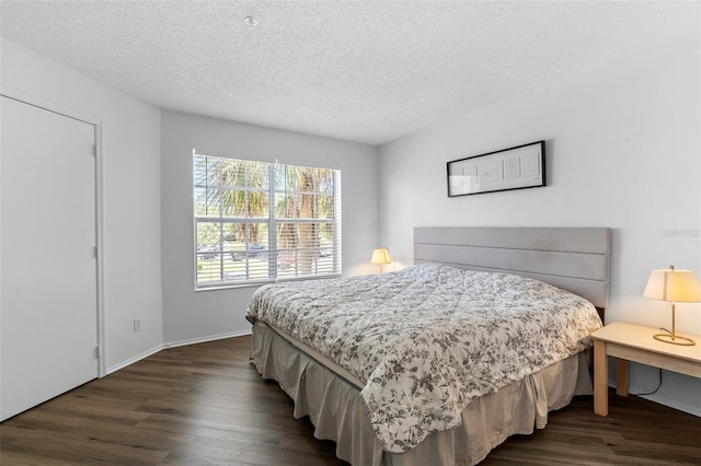 3900 Southpointe Dr Unit 127, Orlando, FL 32822 - bedroom featuring dark wood-style floors, a textured ceiling, and baseboards