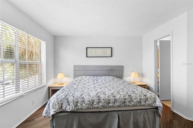 3900 Southpointe Dr Unit 127, Orlando, FL 32822 - bedroom with wood finished floors, a textured ceiling, and baseboards