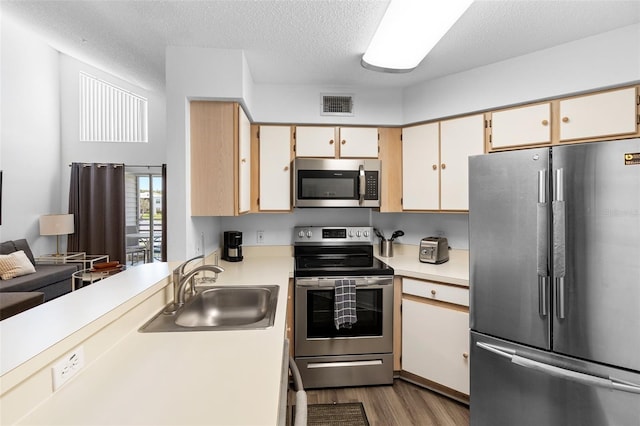 3900 Southpointe Dr Unit 127, Orlando, FL 32822 - kitchen with appliances with stainless steel finishes, a sink, light countertops, dark wood-type flooring, and a textured ceiling