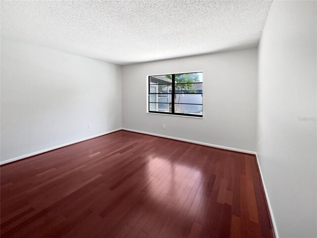 6623 Baybrooks Cir, Temple Terrace, FL 33617 - spare room featuring a textured ceiling, dark wood-style flooring, and baseboards