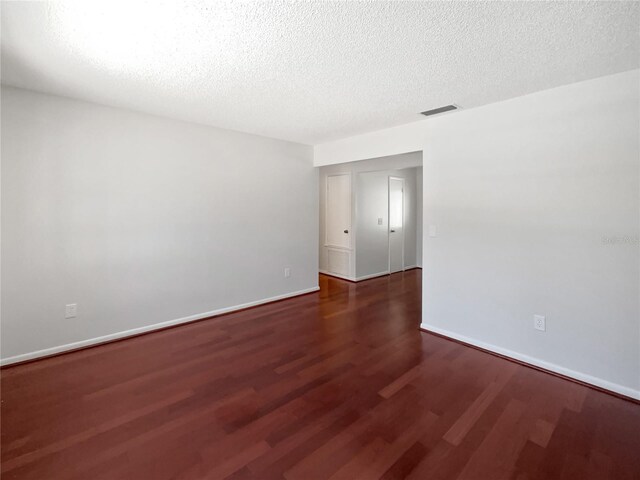 6623 Baybrooks Cir, Temple Terrace, FL 33617 - empty room with wood finished floors, a textured ceiling, and baseboards