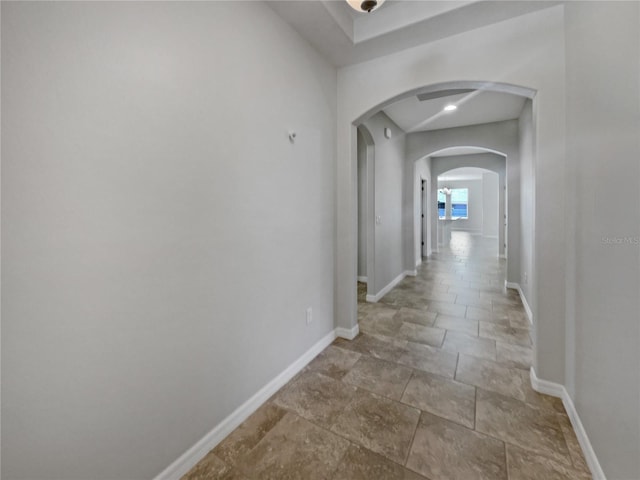 4010 Brookshire Cir, Eustis, FL 32736 - hall featuring arched walkways, baseboards, and stone finish floors
