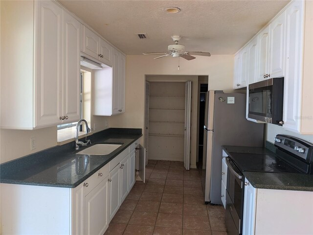 155 Summerset Dr, Punta Gorda, FL 33982 - kitchen with range with electric stovetop, stainless steel microwave, a sink, ceiling fan, and white cabinetry