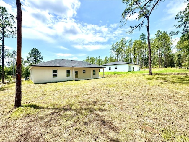1795 W Linden Dr, Citrus Springs, FL 34434 - back of house with a lawn and stucco siding