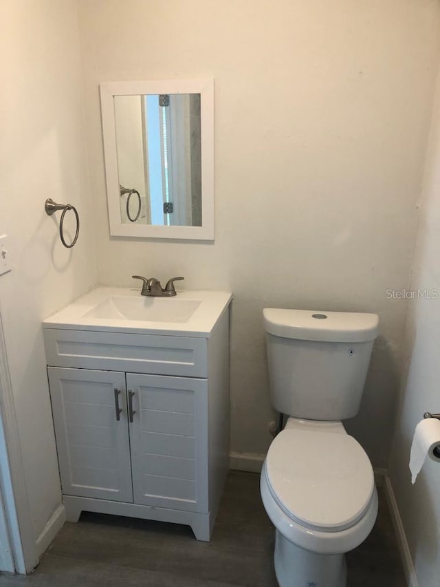 647 Madison Ave, Daytona Beach, FL 32114 - half bathroom with vanity, toilet, and baseboards