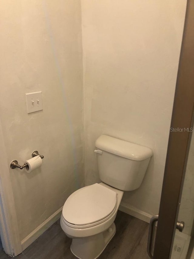 647 Madison Ave, Daytona Beach, FL 32114 - bathroom featuring wood finished floors, toilet, and baseboards