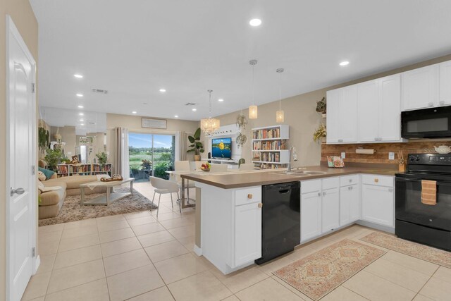 316 Primrose Dr, Davenport, FL 33837 - kitchen with black appliances, a sink, open floor plan, a peninsula, and backsplash