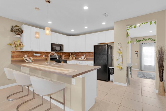 316 Primrose Dr, Davenport, FL 33837 - kitchen featuring black appliances, a peninsula, decorative backsplash, a breakfast bar, and recessed lighting