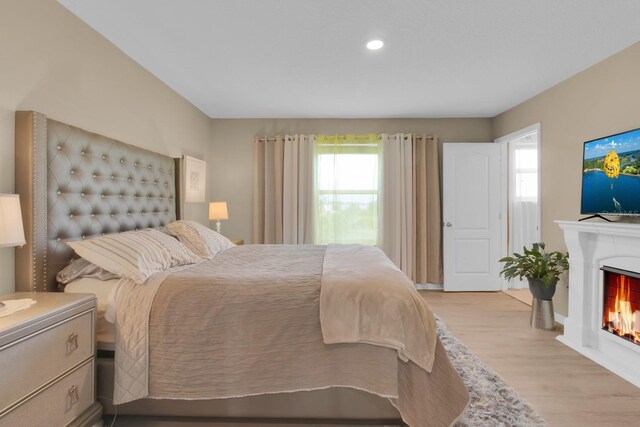 316 Primrose Dr, Davenport, FL 33837 - bedroom featuring multiple windows, wood finished floors, a lit fireplace, and recessed lighting