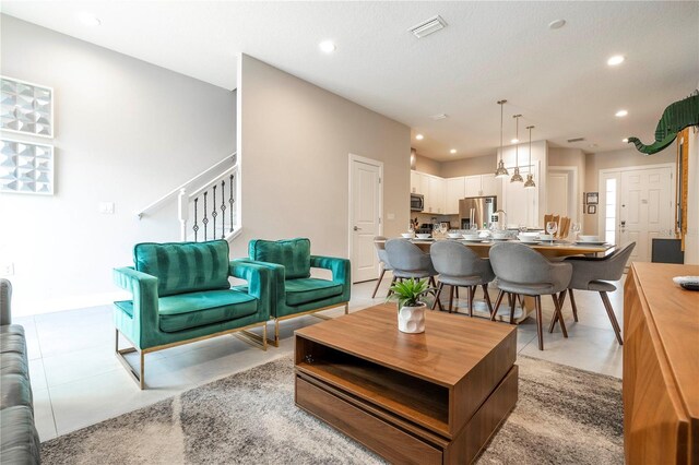 living room featuring stairs, recessed lighting, light tile patterned flooring, and baseboards