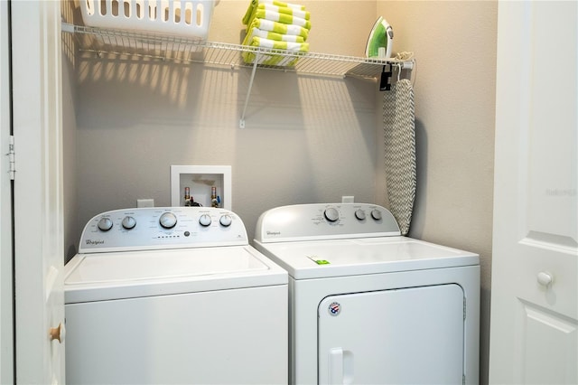 laundry room with washing machine and dryer and a textured wall