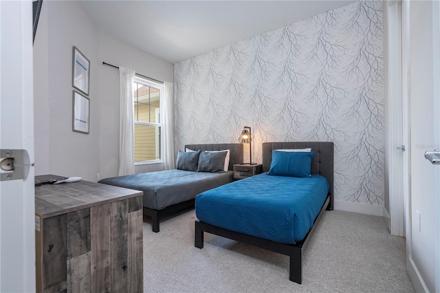 carpeted bedroom featuring wallpapered walls, baseboards, and an accent wall