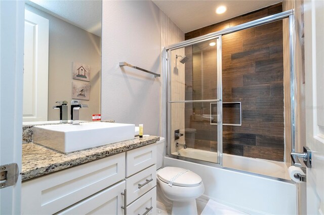 full bath featuring combined bath / shower with glass door, toilet, vanity, and recessed lighting
