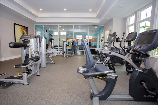 workout area featuring a raised ceiling and recessed lighting