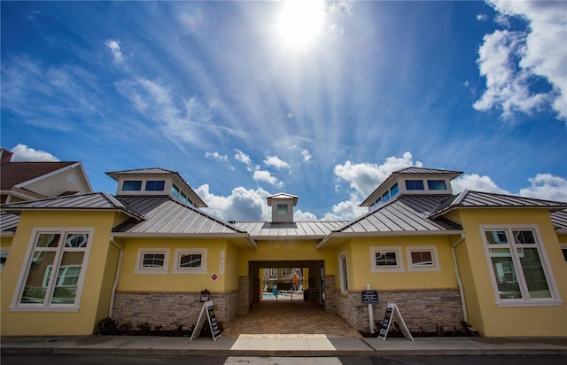 property entrance with a standing seam roof, metal roof, and stucco siding