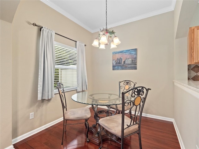 dining area featuring dark wood finished floors, a chandelier, baseboards, and ornamental molding