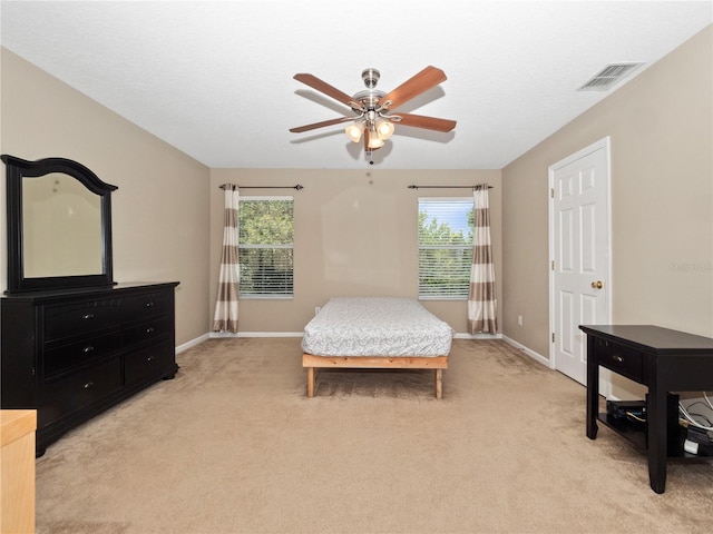 bedroom featuring multiple windows, baseboards, and light colored carpet